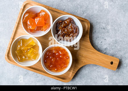 Verschiedene keramische Schüssel von Konfitüren Abb., Quitte, Bergamotte Citrus, Wassermelone in Holz- Fach-/Marmelade. Ökologische Lebensmittel. Stockfoto