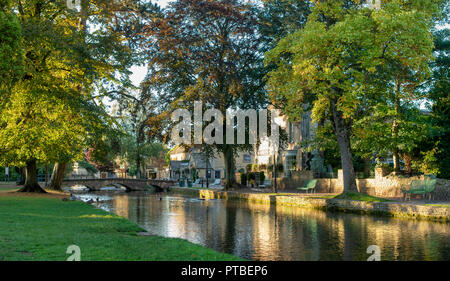 Die kingsbridge Inn und den Fluss Windrush am frühen Morgen Herbst Sonnenlicht. Bourton auf dem Wasser, Cotswolds, Gloucestershire, England. Panoramablick Stockfoto