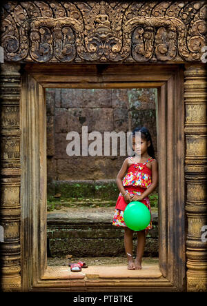 Kambodschanische Mädchen mit einem grünen Ballon in Banteay Srei Tempel Tor, Provinz Siem Reap, Angkor, Kambodscha Stockfoto