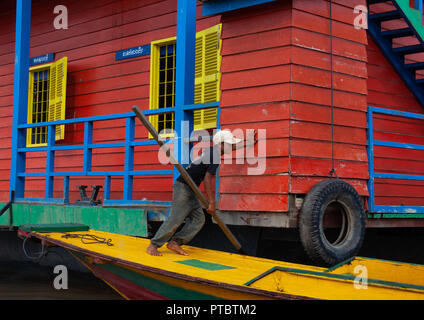 Junge sein Boot drücken in die schwimmenden Dorf am Tonle Sap See, Provinz Siem Reap, Chong Kneas, Kambodscha Stockfoto