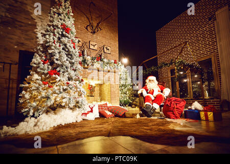 Santa Claus in einem Raum mit einem Kamin in Weihnachten Stockfoto