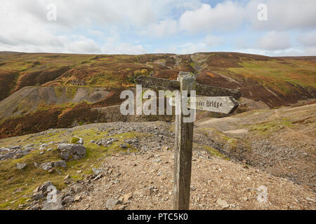 Fußweg zeichen Brücke und Blakethwaite Dämme in der Nähe der Überreste der einst blühenden führen Bergbau aufzugeben, Teil der Buntung Mine, Gunnersi Stockfoto