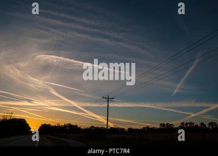 Jet Kondensstreifen kreuz und quer durch den Himmel bei Sonnenuntergang in North Central Florida. Stockfoto