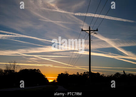 Jet Kondensstreifen kreuz und quer durch den Himmel bei Sonnenuntergang in North Central Florida. Stockfoto