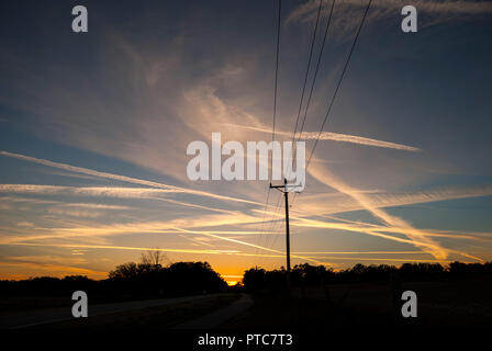 Jet Kondensstreifen kreuz und quer durch den Himmel bei Sonnenuntergang in North Central Florida. Stockfoto