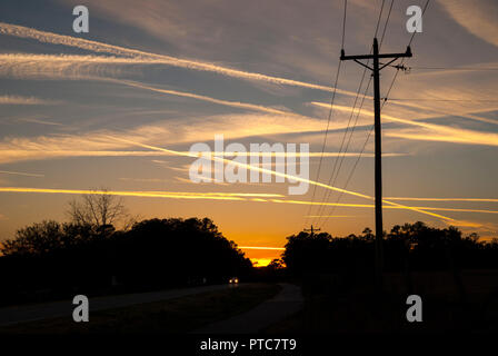 Jet Kondensstreifen kreuz und quer durch den Himmel bei Sonnenuntergang in North Central Florida. Stockfoto