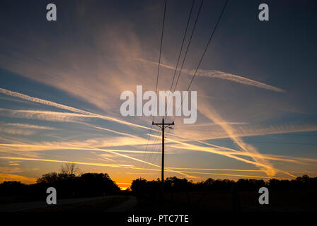 Jet Kondensstreifen kreuz und quer durch den Himmel bei Sonnenuntergang in North Central Florida. Stockfoto