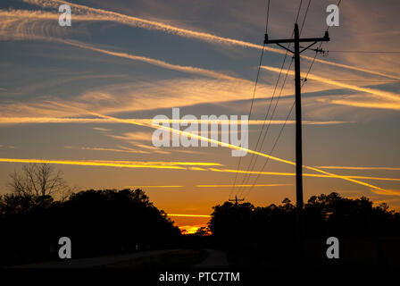 Jet Kondensstreifen kreuz und quer durch den Himmel bei Sonnenuntergang in North Central Florida. Stockfoto