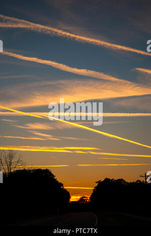 Jet Kondensstreifen kreuz und quer durch den Himmel bei Sonnenuntergang in North Central Florida. Stockfoto