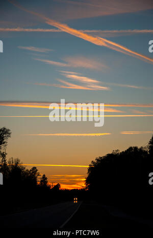 Jet Kondensstreifen kreuz und quer durch den Himmel bei Sonnenuntergang in North Central Florida. Stockfoto