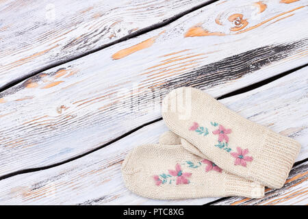 Weibliche woollen Handschuhe, kopieren. Paar Frau schöne gestrickte hand Handschuhe mit floraler Stickerei auf alten rustikalen Hintergrund. Handgefertigte winter fashi Stockfoto