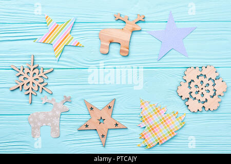 Satz von handgefertigten Neues Jahr und Weihnachtsschmuck. Holz- und Papier geschnitzte Rehe, Sterne, Schneeflocken, Weihnachtsbaum auf blauem Hintergrund Holz, Kopieren s Stockfoto