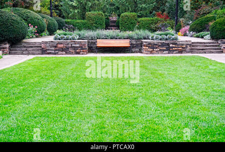 Garten Design mit stoneworks, Blumenbeete, mehrjährige Blumen, Rasen, Hecken und Bäumen in Alexander Muir Memorial Park im Norden von Toronto, Ontario, Stockfoto