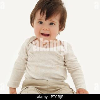 Lustige Baby sitzen auf dem Boden isoliert auf weiß Stockfoto