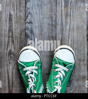 Paare von alten Textil grün Classic sneakers stehen auf einem grauen Hintergrund Holz, Ansicht von oben, kopieren Raum Stockfoto