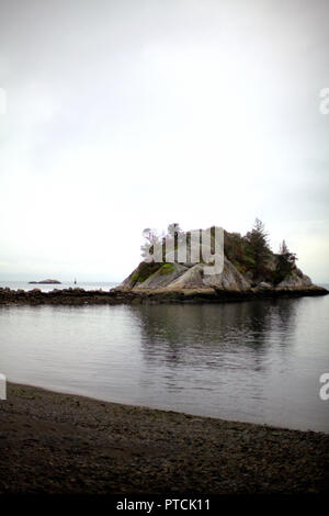 Das whyte Inselchen im Horseshoe Bay, BC, Kanada, an einem regnerischen Tag im Herbst, in dem die weißen Himmel, das ruhige Meer und die felsige Küste Stockfoto