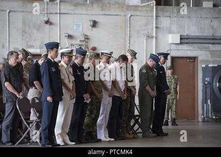 Us-Flieger, Japan Air Verteidigung-kraft Beamte, und verehrte Gäste, ihre Köpfe für den Aufruf im 18 Flügel Ändern des Befehls Zeremonie Juli 10, 2017 Kadena Air Base, Japan Bug. Die Änderung der Befehl ist eine traditionelle militärische Zeremonie, in der die scheidende Befehlshaber Truppen versammelt zur Vorlage bei der eingehenden Commander. Stockfoto