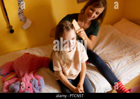 Mutter kämmen Töchter Haar zu Hause Stockfoto