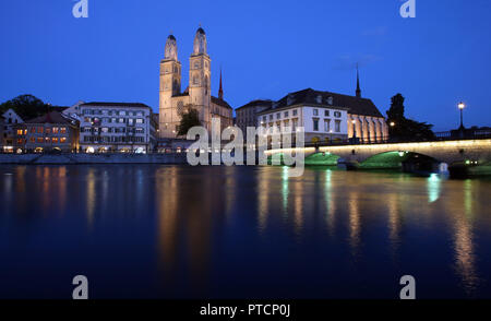 Ein Blick auf das Grossmünster Turm entlang der Limmat bei Dämmerung in Zürich, Schweiz. Stockfoto