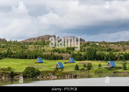 Egilsstadir, Island Cottages oder Kabinen von Fellabaer Stadt und Fluss auf der Ringstraße mit traditionellen Hütte Architektur, blauen Dächer für Camping Stockfoto