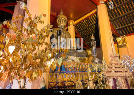 Altar mit mehreren goldenen Buddha Statuen und andere Einzelteile am Wat Ong Teu Mahawihan (Tempel der schweren Buddha), ein buddhistisches Kloster, in Vientiane Stockfoto