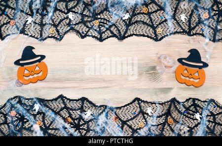 Halloween Hintergrund. Schwarz cobweb Spitzenabschluss und Jack-o-Lantern Dekorationen auf dem Holz- Hintergrund mit Freiraum für Halloween text Stockfoto