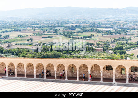 Assisi, Italien - 29 August 2018: Stadt oder Dorf Stadt in Umbrien, Kirche Bögen Pfad Luftaufnahme unten während der sonnigen Sommertag, niemand, Bauernhof ländliche Grundstücke Stockfoto