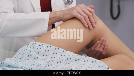 Ansicht schließen der leitenden Arzt zu jungen womans verletzten Knie tendenziell Stockfoto