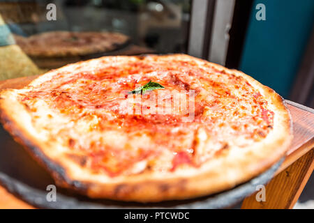 Makro Nahaufnahme von frischen dünne Kruste handgefertigte Pizza in Store Bäckerei auf dem Display durch Fenster oder Restaurant Cafe in Italien mit geschmolzenem Mozzarella, glänzend Stockfoto