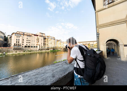 Junge Fotografen, die Bilder von Firenze Florenz farbenfrohe Gebäude und Arno in Italien mit Kamera im Sommer in der Toskana Stockfoto