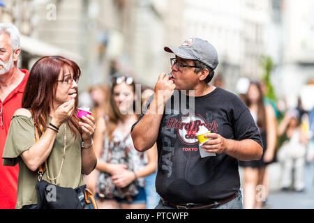 Firenze, Italien - 30. August 2018: Die paar Touristen Menschen außerhalb Essen gelato Eis mit Löffel an heißen Tag in Florenz, Toskana Stockfoto