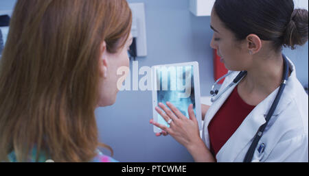 In der Nähe von schönen Latina Arzt holding Tablet zu überprüfen Patienten hip x-ray Stockfoto