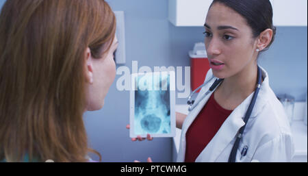 In der Nähe von schönen Latina Arzt holding Tablet zu überprüfen Patienten hip x-ray Stockfoto