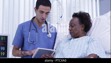 Portrait von jungen männlichen MD mit Tablet für Patienten ihre Gesundheit Zustand anzeigen Stockfoto