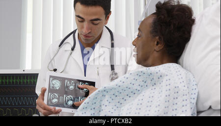 Portrait von spanischer Arzt, CT-Scans auf Tablet zu Patient Stockfoto