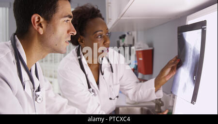 Zwei Ärzte überprüfen Patient x-ray von Patienten Wirbelsäule und Schädel Stockfoto