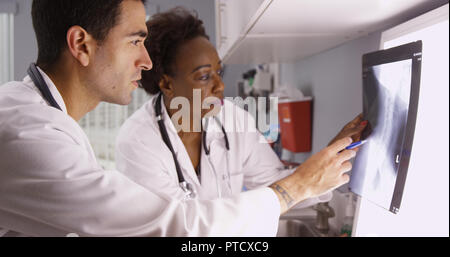 Zwei Ärzte überprüfen Patient x-ray von Patienten Wirbelsäule und Schädel Stockfoto