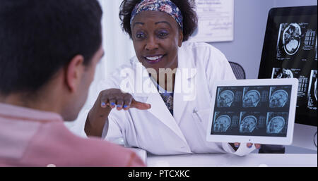 Nahaufnahme der Ärztin zu jungen Latino Patienten Ergebnisse von seinem mri erklären Stockfoto