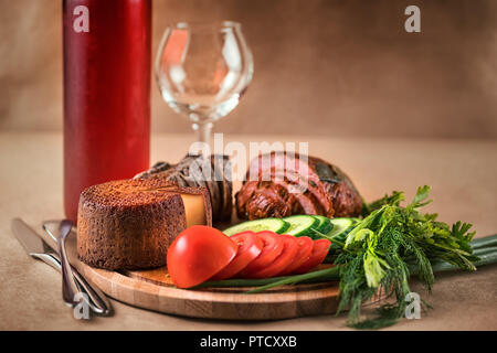 Noch immer leben mit Essen und Trinken. Schinken, Käse, Gemüse und Rotwein auf Handwerk Hintergrund Stockfoto