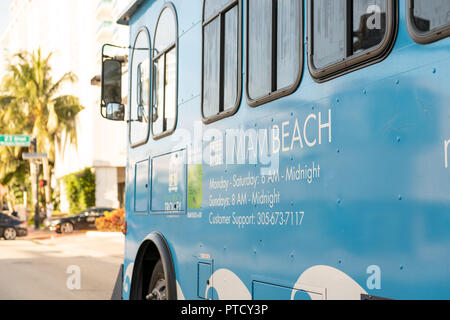 South Beach, USA - Mai, 2018: Blau Miami Beach Trolley, Bus, Fahrzeug bietet freie Fahrt auf der Straße, Straße, Kreuzung mit der Treiber Windows, Spiegel in F Stockfoto