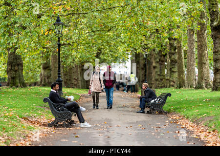 London, Großbritannien - 12 September 2018: Paar in der Gasse Pfad im Green Park in Westminster, Querformat während der grünen Regenzeit nasse Sommer, Herbst in Un Stockfoto