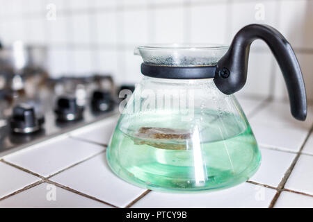 Malva Kräutertee auf weißen Fliesen Arbeitsplatte durch Gas Herd mit Teekanne Topf in der Küche zu Hause, grün blau türkis Stockfoto
