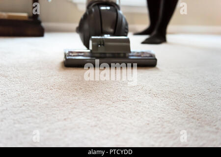 Nahaufnahme der Frau, weiblich, Reinigung zu Hause mit Staubsauger, Leiter, Pinsel auf dem Teppich boden Stockfoto