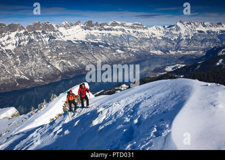 Zwei Bergsteiger auf einer Skitour im Winter, Aufstieg auf Snow Ridge, hinter den Walensee und die Churfirsten und Appenzeller Alpen Stockfoto