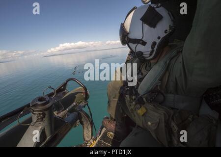 CORAL SEA (8. Juli 2017) Crew Chief Cpl. Gerald Demontmollin, von Grass Valley, Kalifornien, bietet die taktische Navigation Hilfe für Piloten in einem UH-Y Huey Hubschrauber, zugeordnet zu den Marine Medium Tiltrotor Squadron (VMM) 265 (verstärkt), zur Unterstützung von Marines zugeordnet. bis 31 Marine Expeditionary Unit (MEU), und schiffte sich an Bord des amphibious Transport dock USS Green Bay LPD (20), in der Bildung von Bekämpfung Gummi überfällt, Handwerk, während einer Amphibischen raid-Probe als Teil der Talisman Sabre 17. Green Bay, Teil einer kombinierten US-Australia-New Zealand Expeditionary strike Group, durchläuft Stockfoto