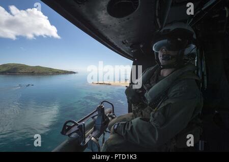 CORAL SEA (8. Juli 2017) Crew Chief Cpl. Gerald Demontmollin, von Grass Valley, Calif., gibt taktische Informationen zu ein Pilot in einem UH-Y Huey Hubschrauber, zugeordnet zu den Marine Medium Tiltrotor Squadron (VMM) 265 (verstärkt), damit die Unterstützung für die Bildung von Marines zugeordnet. bis 31 Marine Expeditionary Unit (MEU) im Kampf Gummi Streifzüge Handwerk in Richtung Crowley Strand während einer Amphibischen raid-Probe als Teil der Talisman Sabre 17 vorangegangen geben. Die 31 MUE ist an Bord des amphibious Transport dock USS Green Bay LPD (20), Teil einer kombinierten US-Australia-New Zealand Expeditionary str eingeleitet Stockfoto