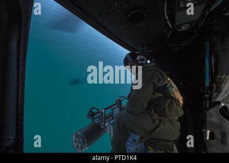 CORAL SEA (8. Juli 2017) Crew Chief Cpl. Gerald Demontmollin, von Grass Valley, Calif., gibt taktische Informationen zu ein Pilot in einem UH-Y Huey Hubschrauber, zugeordnet zu den Marine Medium Tiltrotor Squadron (VMM) 265 (verstärkt), damit die Unterstützung für die Bildung von Marines zugeordnet. bis 31 Marine Expeditionary Unit (MEU) im Kampf Gummi Streifzüge Handwerk in Richtung Crowley Strand während einer Amphibischen raid-Probe als Teil der Talisman Sabre 17 vorangegangen geben. Die 31 MUE ist an Bord des amphibious Transport dock USS Green Bay LPD (20), Teil einer kombinierten US-Australia-New Zealand Expeditionary str eingeleitet Stockfoto