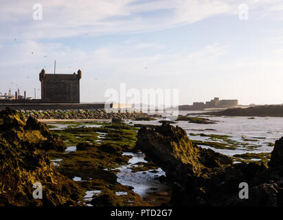 ESSAOUIRA, MAROKKO - ca. Mai 2018: Sonnenuntergang über dem Hafen von Essaouria und die berühmten Castelo Real von Mogador. Stockfoto