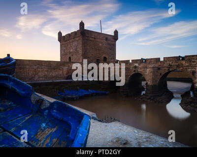 ESSAOUIRA, MAROKKO - ca. Mai 2018: Sonnenuntergang über dem Hafen von Essaouria und die berühmten Castelo Real von Mogador. Stockfoto