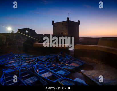 ESSAOUIRA, MAROKKO - ca. Mai 2018: Sonnenuntergang über dem Hafen von Essaouria und die berühmten Castelo Real von Mogador. Stockfoto